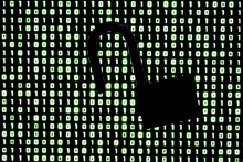 Un cadenas devant un code binaire affiché sur l'écran d'un ordinateur portable (image d'illustration)