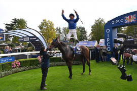 Le jockey italien Frankie Dettori réalise "le saut de l'ange" après sa victoire à l'hippodrome d'Ascot, le 21 octobre 2023