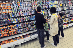 Une famille fait ses achats de rentrée scolaire dans une grande surface.
