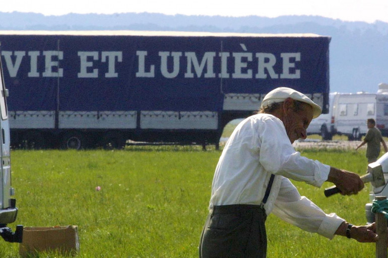 Une personne plante un piquet sur une base aérienne accueillant un rassemblement évangélique tzigane de quelque 40.000 personnes organisé par l'association "Vie et lumière" (Image d'illustration).