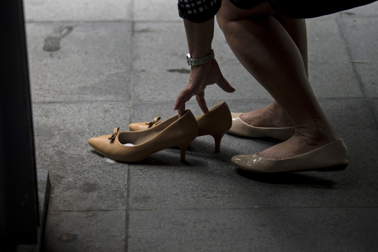 Une employée change de chaussures en sortant de son travail à Manille, aux Philippines