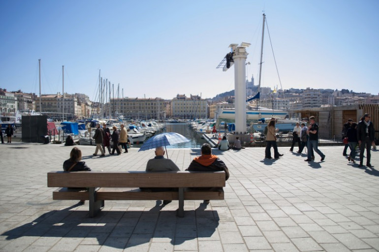 Des personnes profitent du soleil sur le Vieux Port de Marseille.