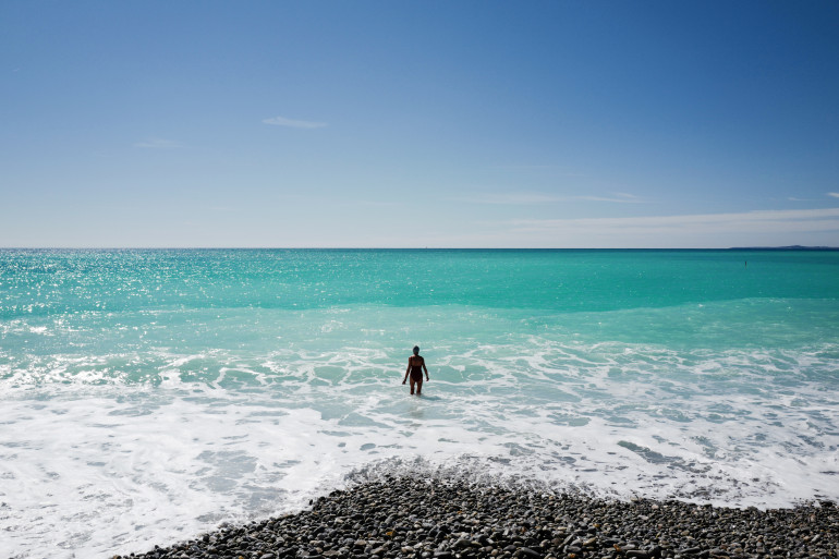 Une dame se baigne sur une plage de Nice (illustration)