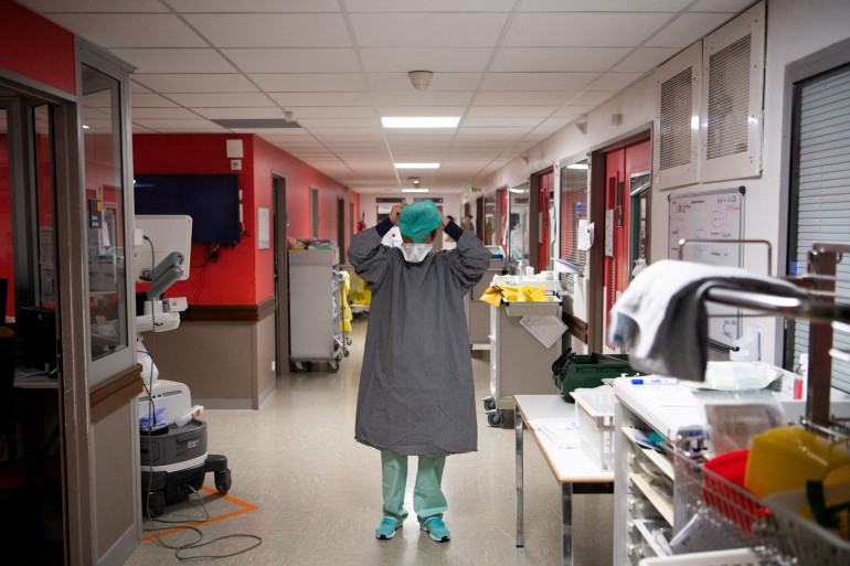 Un agent de santé met un équipement de protection dans le service de soins intensifs pour les patients infectés par le Covid-19 de l'hôpital Cavale Blanche à Brest, le 4 novembre 2020.