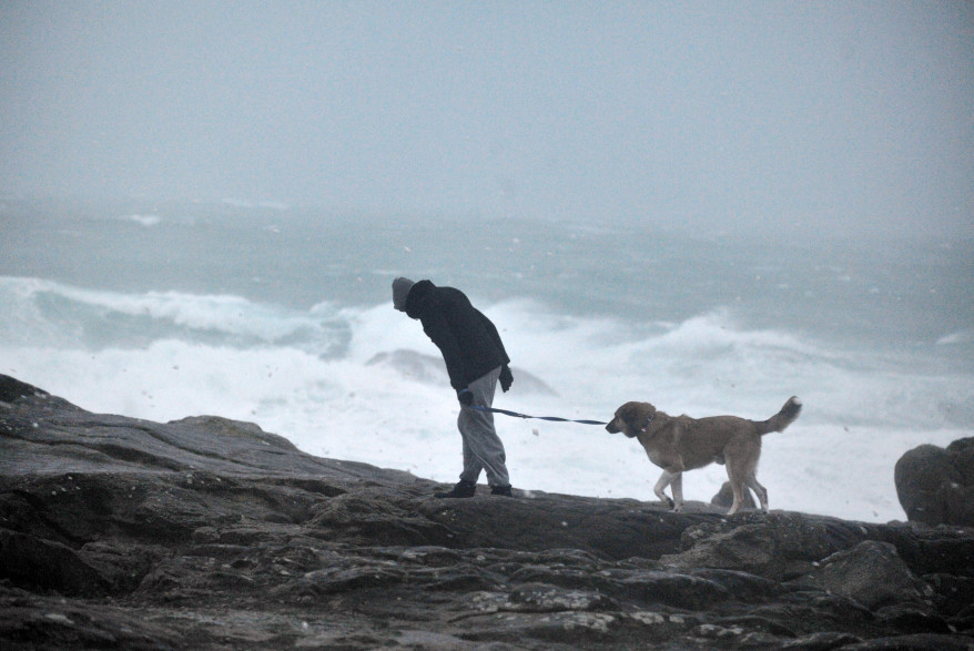 Un homme promène son chien sur la plage de Saint-Guenole, dans l'ouest de la France, le 23 décembre 2013.