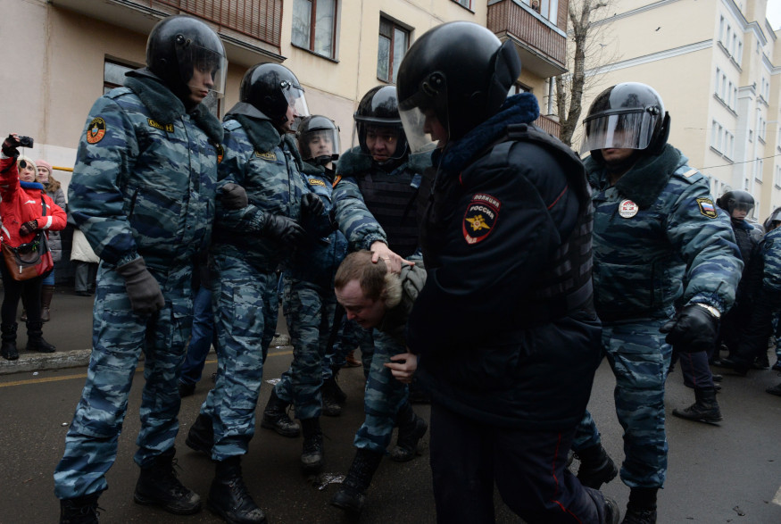 Des policiers anti-émeutes arrêtent des protestataires devant le tribunal de Moscou jugeant des manifestants anti-Poutine, le 24 février 2014.