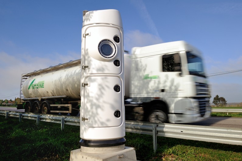 Un camion de transport passe à côté d'une borne écotaxe à Lisieux