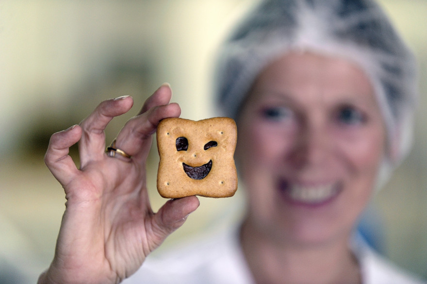 Une employée de la biscuiterie BN pose avec un biscuit
