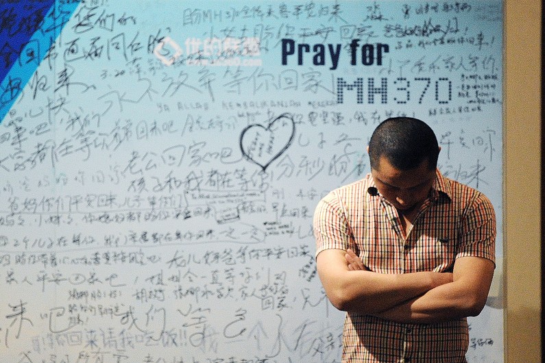 Un homme se tient devant un tableau d'hommages aux victimes du vol MH370 de la Malaysia Airlines, le 23 avril 2014.