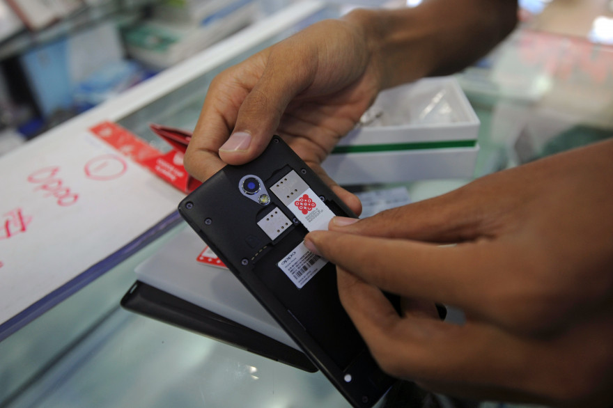 Un vendeur introduit une carte SIM dans un téléphone (illustration).