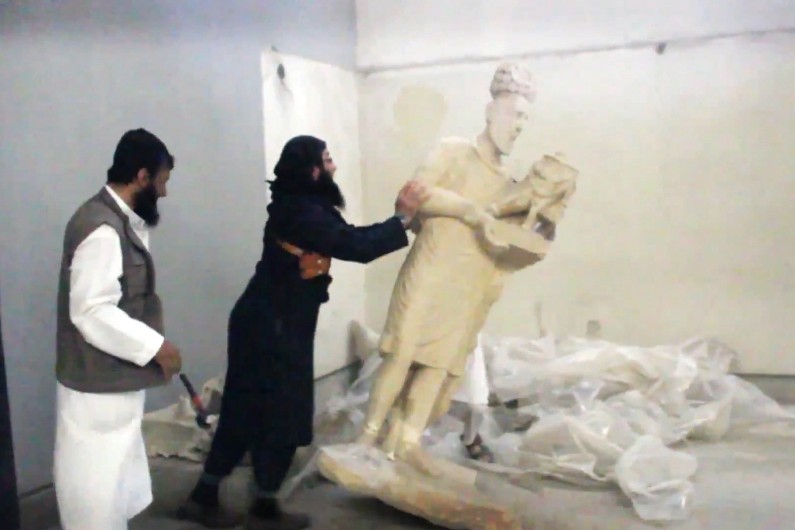Un jihadiste de l'Etat islamique en train de détruire une sculpture à Mossoul, en Irak.