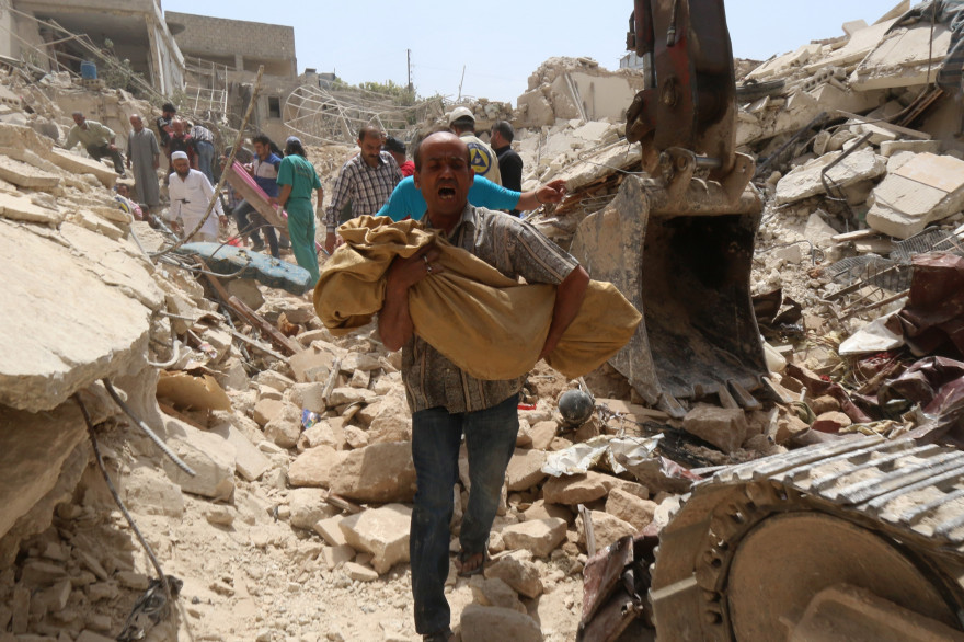Un Syrien porte un corps après un bombardement à Alep
