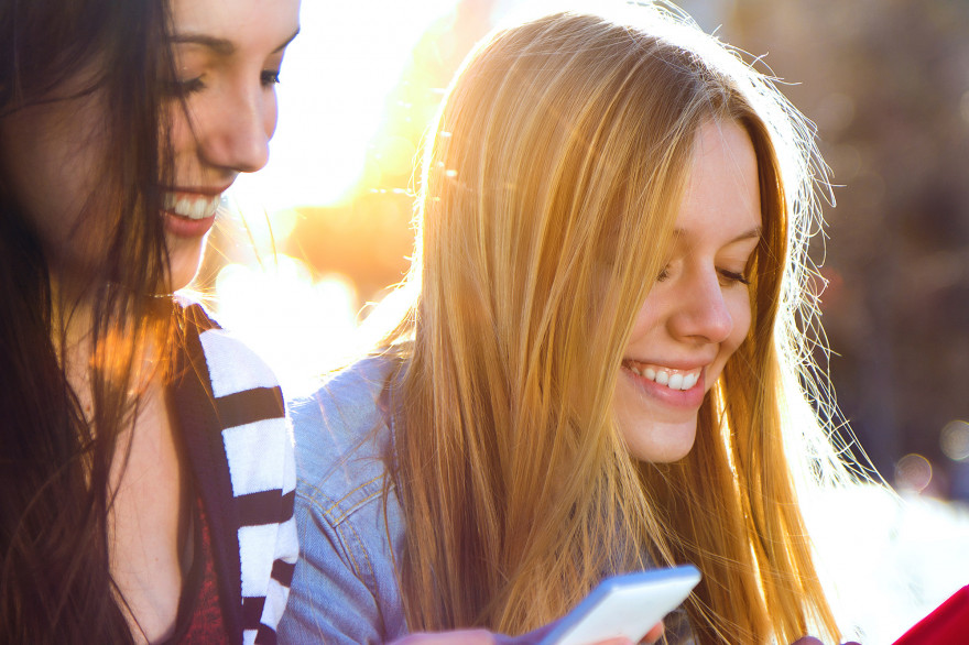 Des jeunes filles jouant sur leur smartphone