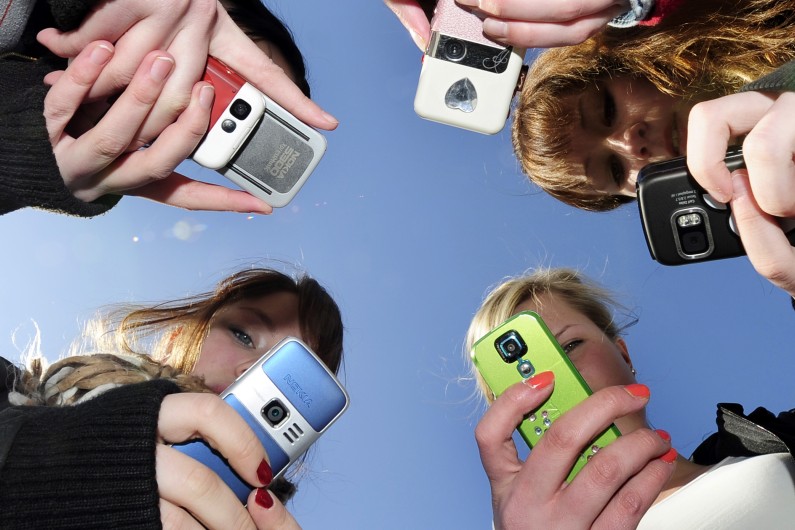 Des jeunes filles consultant leurs portables (illustration)