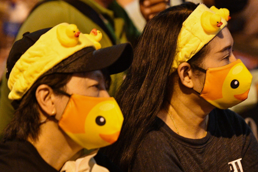 Des manifestants pro-démocratie portent masques et accessoires à l'effigie d'un canard jaune lors d'un rassemblement à Bangkok le 2 décembre