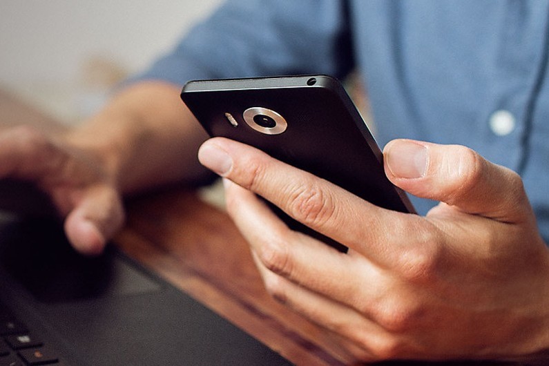 Un homme tient son téléphone à la main (illustration)