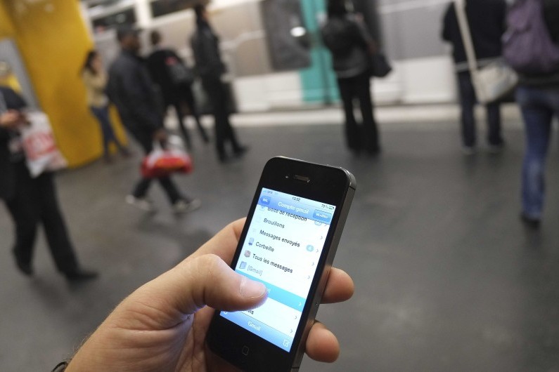 Une personne consulte son smartphone dans le métro à Paris