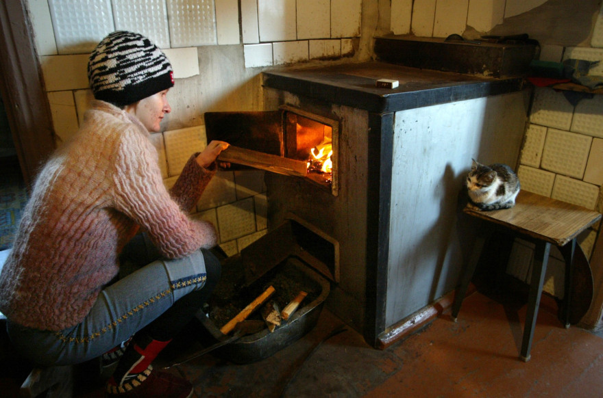 Une femme allume un chauffage à bois (photo d'illustration).