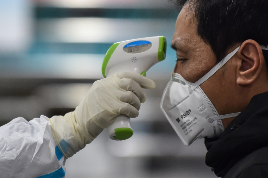 La Croix-Rouge prend la température d'un homme à Wuhan le 25 janvier 2020, en pleine épidémie de coronavirus.