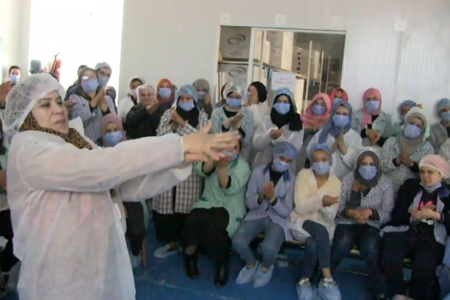 Une cadre de Consomed explique les consignes d'hygiène aux employés de l'usine.