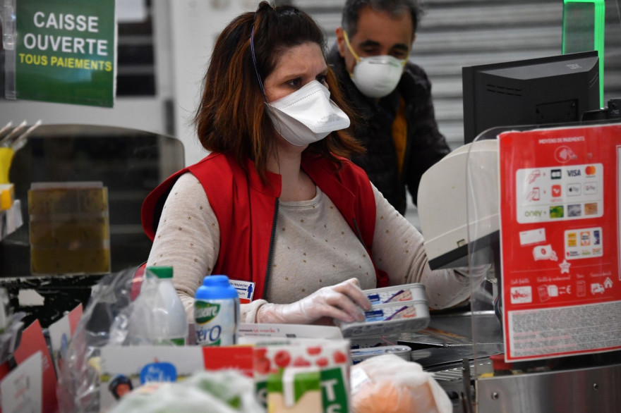 Une caissière portant un masque pour se protéger du coronavirus, le 30 mars 2020, dans un supermarché à Montpellier