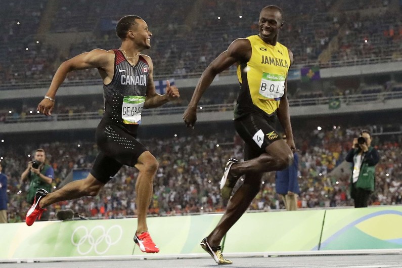 Usain Bolt et Andre De Grasse s'échangent des sourires lors de la demi-finale du 200m à Rio.