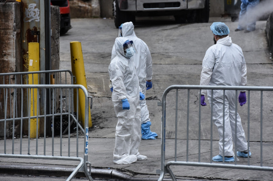 Des agents contractuels en combinaisons blanches enterrent les corps des morts du Covid-19 à New York