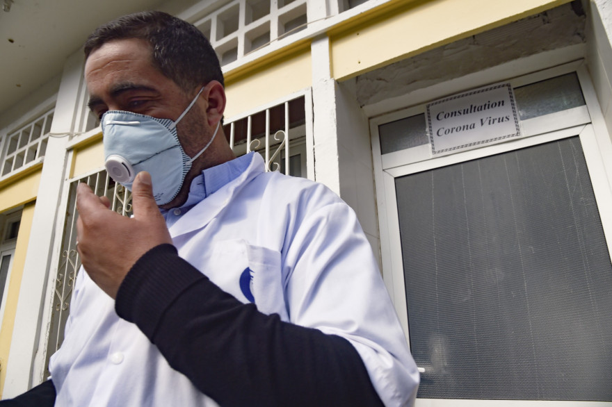 Un médecin d'Alger ajustant son masque