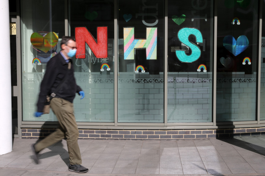 Un homme portant un masque contre le coronavirus, devant le NHS (National Health Service) à Londres, le 11 mai 2020.