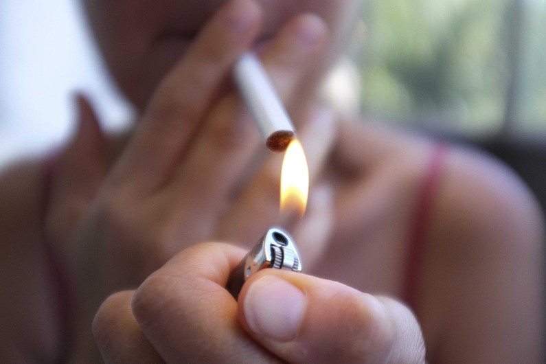 Une femme fume une cigarette (illustration)