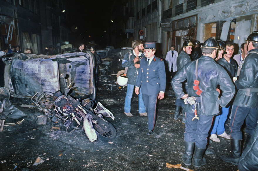 Des pompiers s'affairent, le 03 octobre 1980 à Paris, autour de véhicules détruits par l'explosion d'un engin explosif visant la synagogue de la rue Copernic.