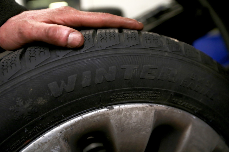 Un automobiliste tient un pneu hiver (illustration)