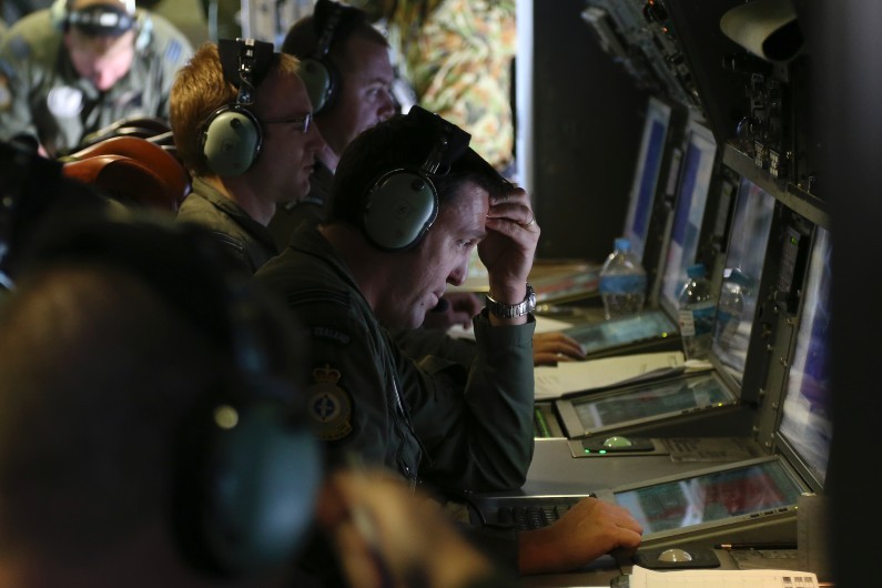 Des soldats australiens scrutent des images de l'océan à la recherches de traces de l'avion de la Malaysia Airlines, le 4 avril 2014