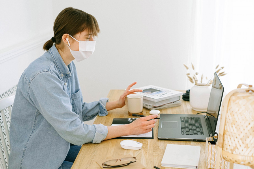 Une femme portant son masque chez elle en télétravail (Image d'illustration).
