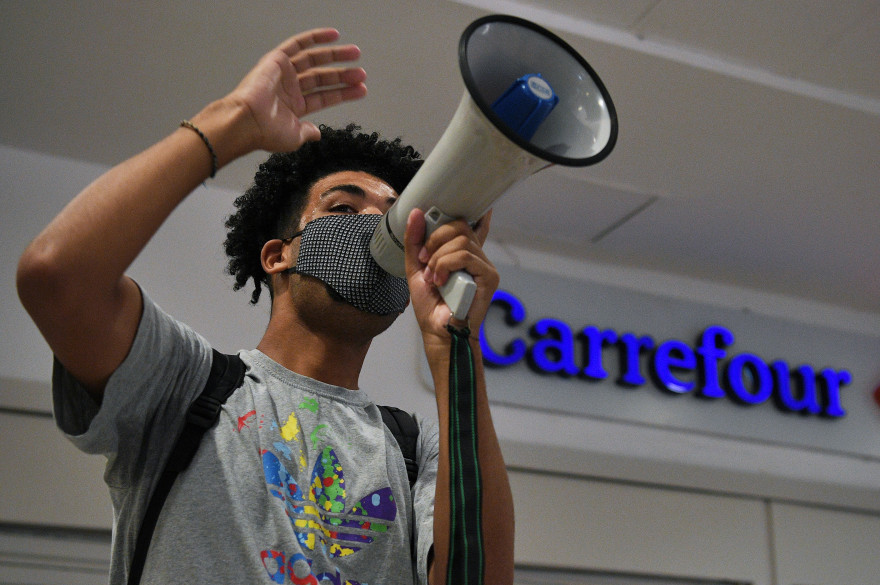 Un homme s'adresse à des manifestants devant un magasin Carrefour, le 22 novembre 2020