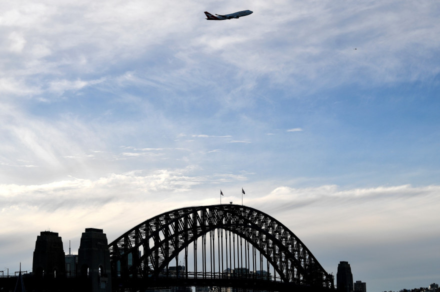 Un avion de ligne Qantas Boeing 747 survolant le pont de Sydney