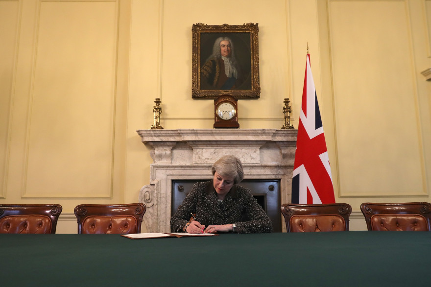 La Première ministre britannique Theresa May signe la lettre qui doit activer le Brexit, mardi 28 mars.
