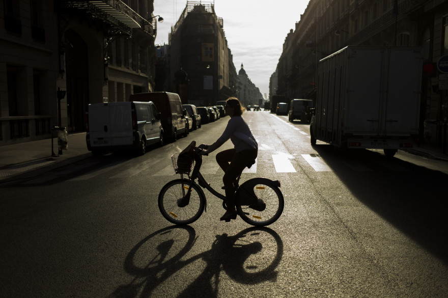 Une femme passe à vélo dans une rue de Paris (illustration)