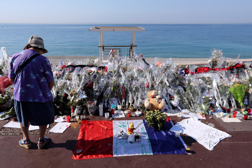 Une personne se recueillant sur la promenade des Anglais à Nice