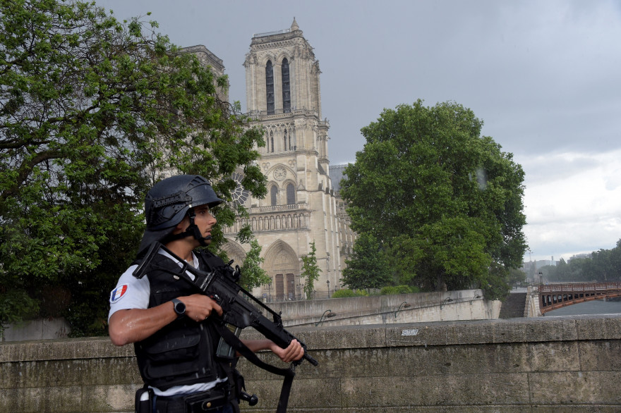Un policier tenant une arme à feu à proximité de Notre-Dame-de-Paris