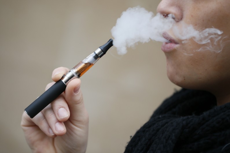 Un homme fume une cigarette électronique (Image d'illustration)
