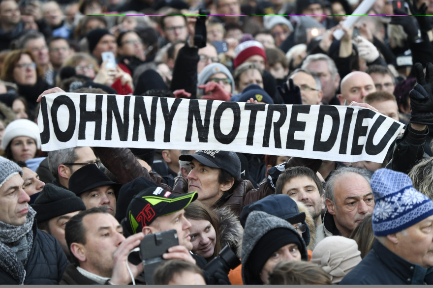 Des fans rassemblés devant l'église de La Madeleine avant une cérémonie lors d'un "hommage populaire" à Johnny Hallyday le 9 décembre 2017 à Paris.