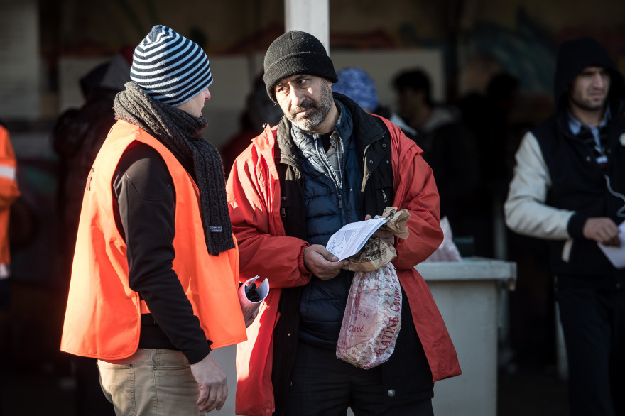 Un membre de l'OFPRA avec un migrants à Calais en 2016 (archives)