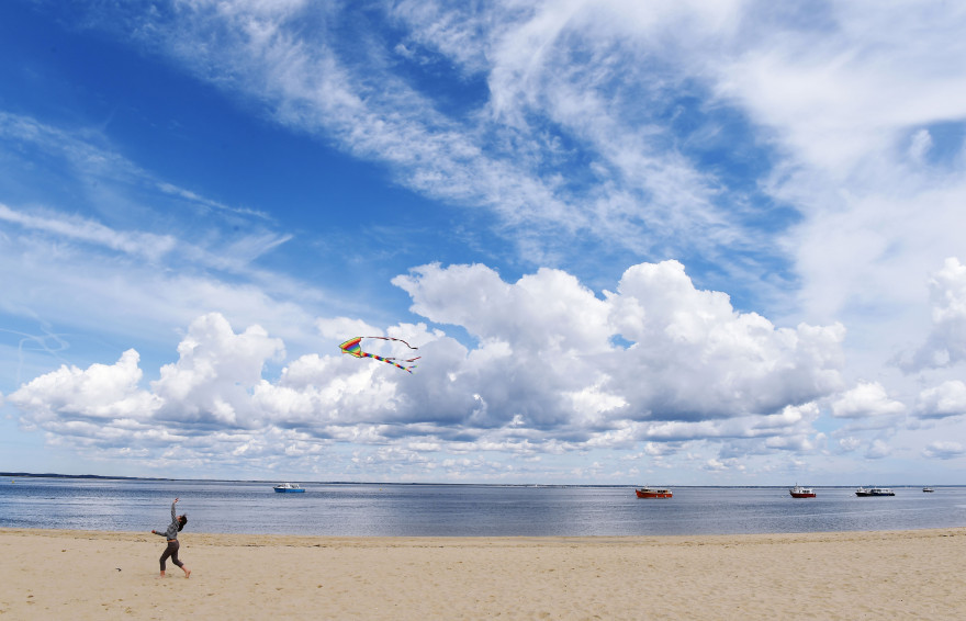 un enfant joue avec un cerf-volant à Arcachon (Gironde).