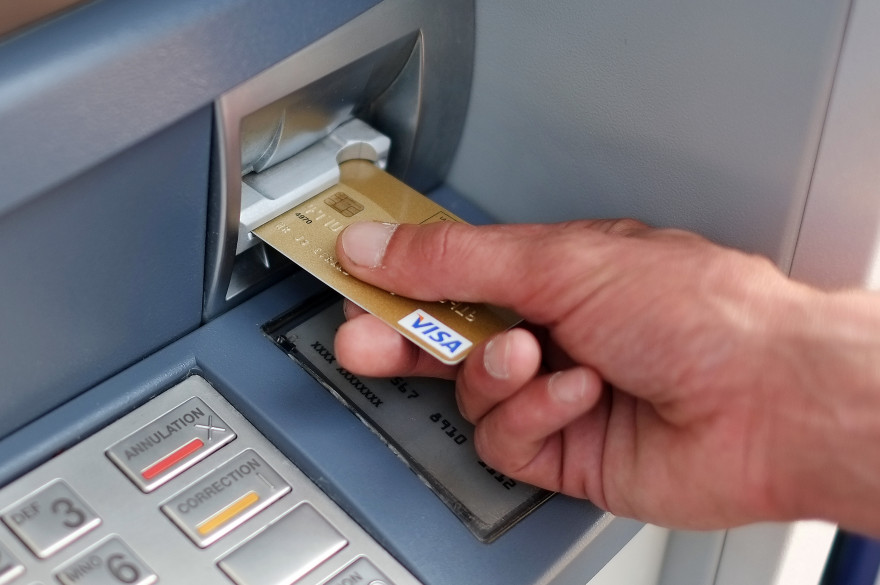 Un homme retire de l'argent à un distributeur à billets (illustration)