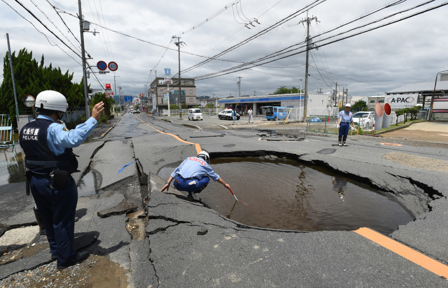 La police japonaise constate l'effondrement d'une route suite à un séisme à Tanatsuki.