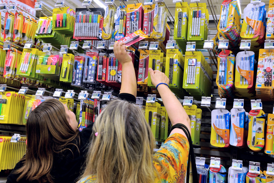 Une mère et sa fille achètent des fournitures scolaires dans un supermarché (illustration)
