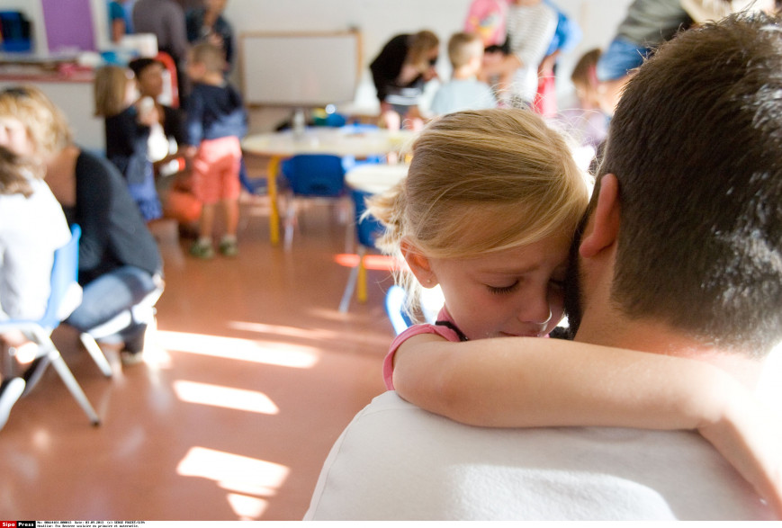 Une petite fille entre à l'école maternelle (illustration).