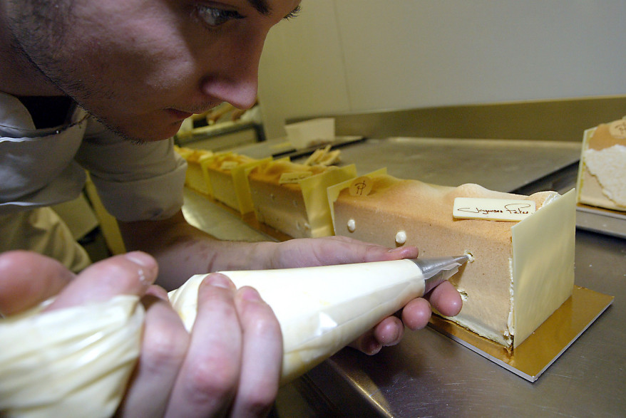 Un pâtissier prépare une buche de Noël (illustration)