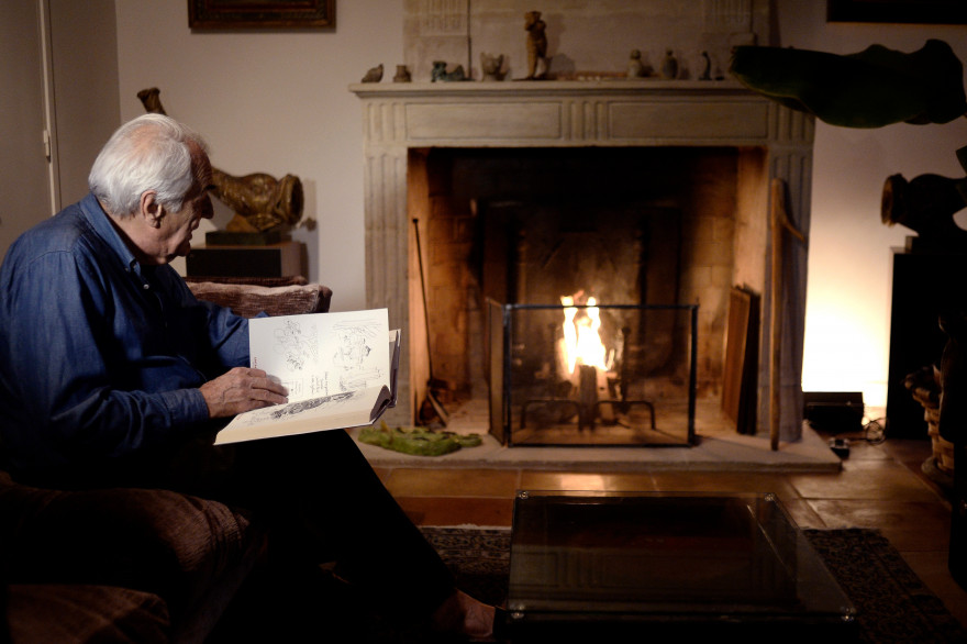Un homme lit un livre devant un feu de cheminée en 2014 à Paris (illustration)